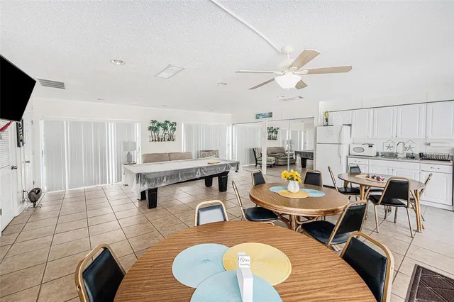 a kitchen with granite countertop a white stove top oven a sink dishwasher and white cabinets with wooden floor