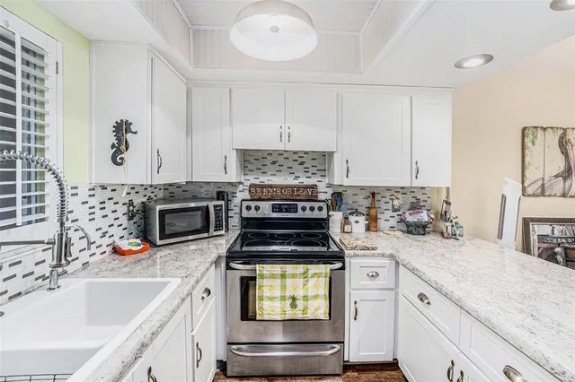a kitchen with granite countertop a stove sink and cabinets