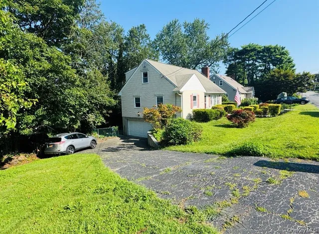 a view of a house with a big yard and large trees