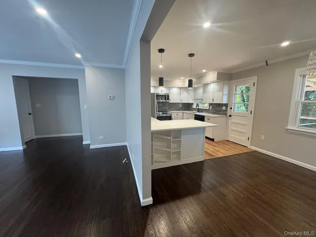 a view of a kitchen with cabinets and wooden floor