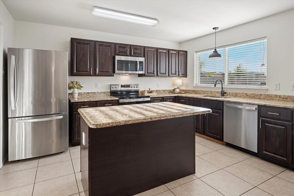 13837 High Mesa Road Fort Worth, TX 76262 - Photo 9 of 25 a kitchen with stainless steel appliances granite countertop a sink stove and refrigerator