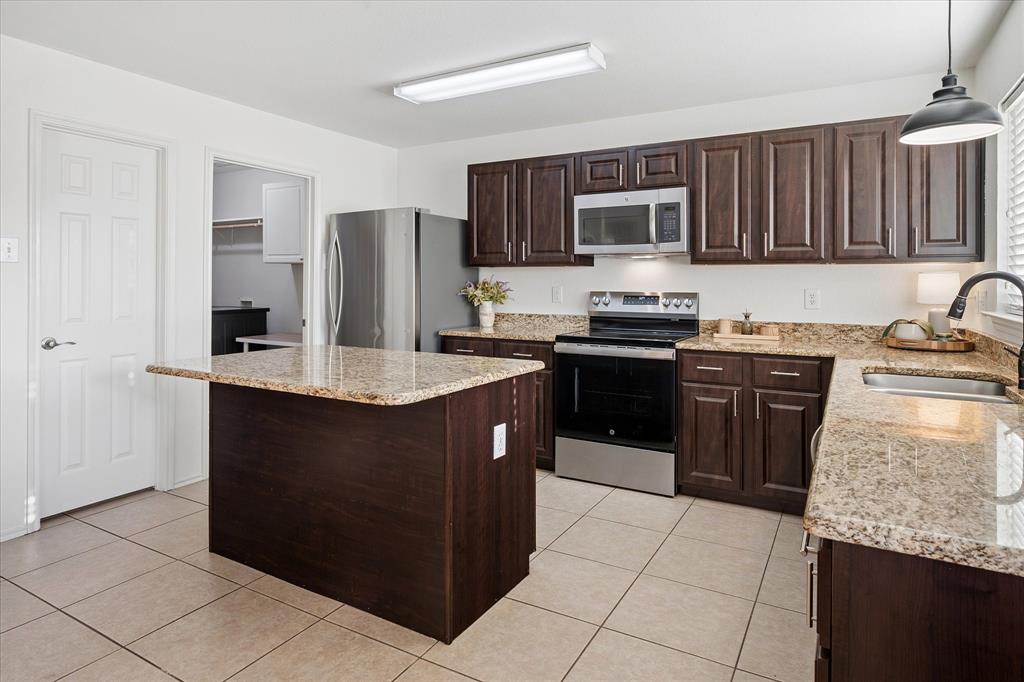 13837 High Mesa Road Fort Worth, TX 76262 - Photo 10 of 25 a kitchen with stainless steel appliances granite countertop a stove a sink dishwasher and a refrigerator