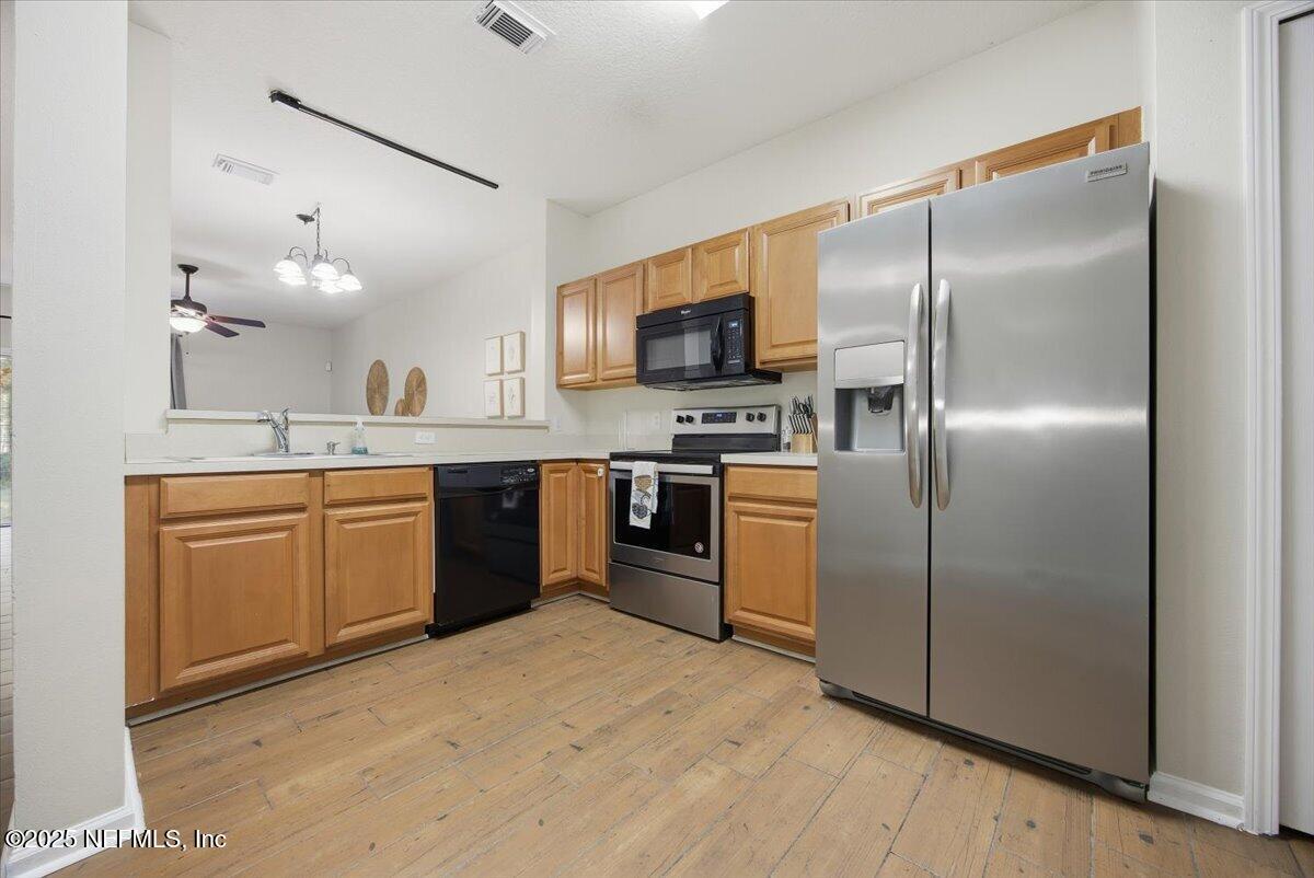 446 Scrub Jay Drive St. Augustine, FL 32092 - Photo 2 of 20 a kitchen with a refrigerator sink and wooden floor