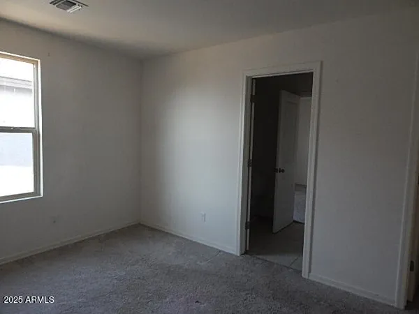 an empty room with windows and closet