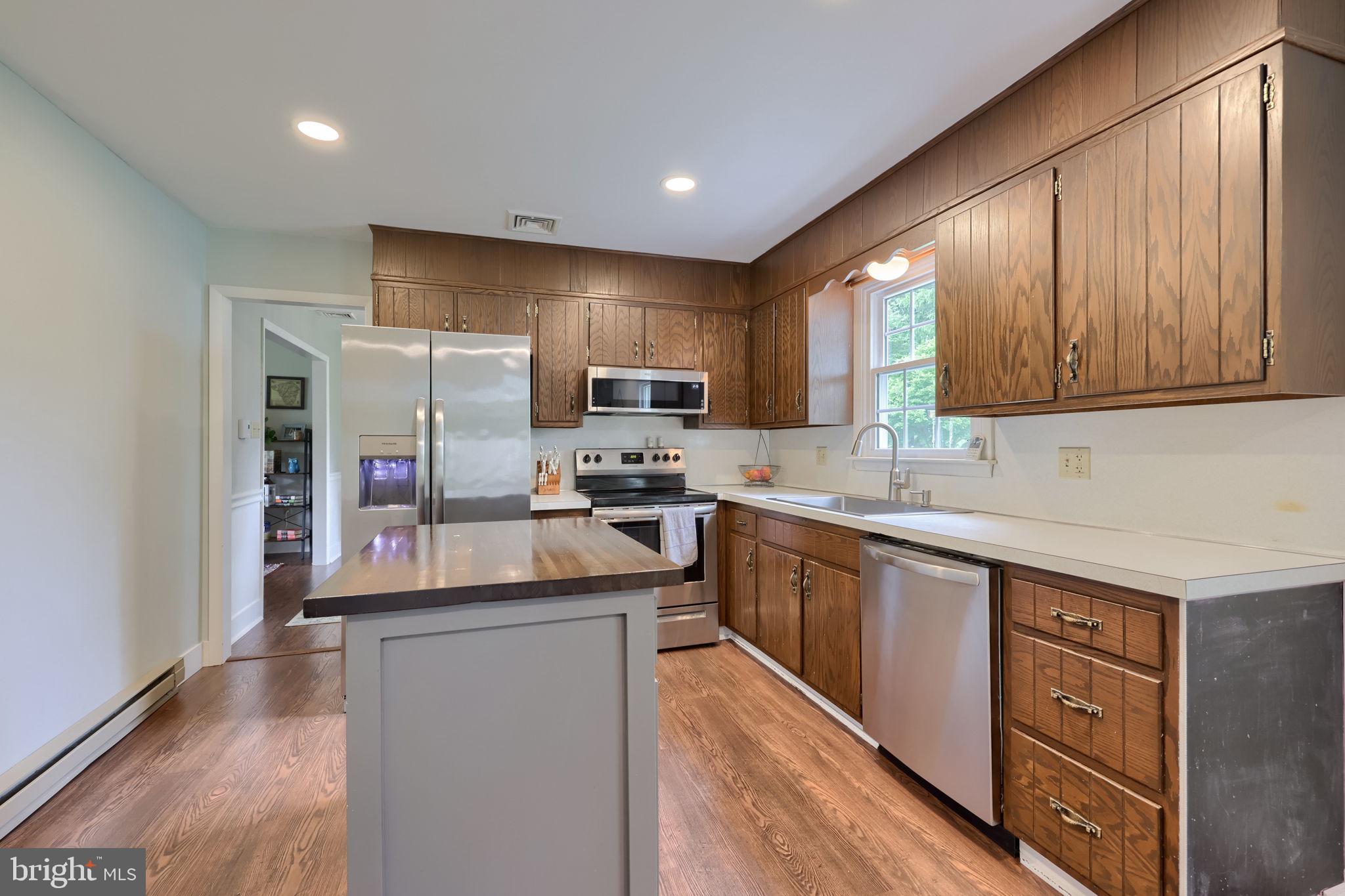 1019 Devonshire Road Lancaster, PA 17601 - Photo 10 of 35 a kitchen with stainless steel appliances granite countertop wooden cabinets a sink and dishwasher a stove top oven with wooden floor