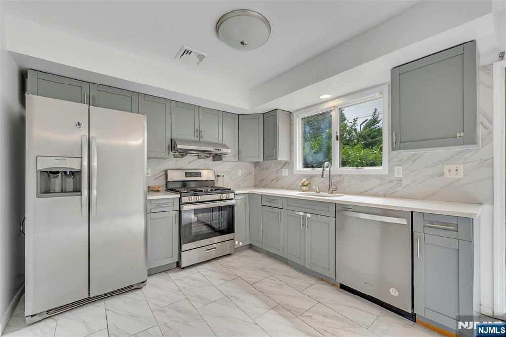 2410 3rd Street Fort Lee, NJ 07024 - Photo 11 of 37 a kitchen with stainless steel appliances granite countertop a refrigerator sink and stove