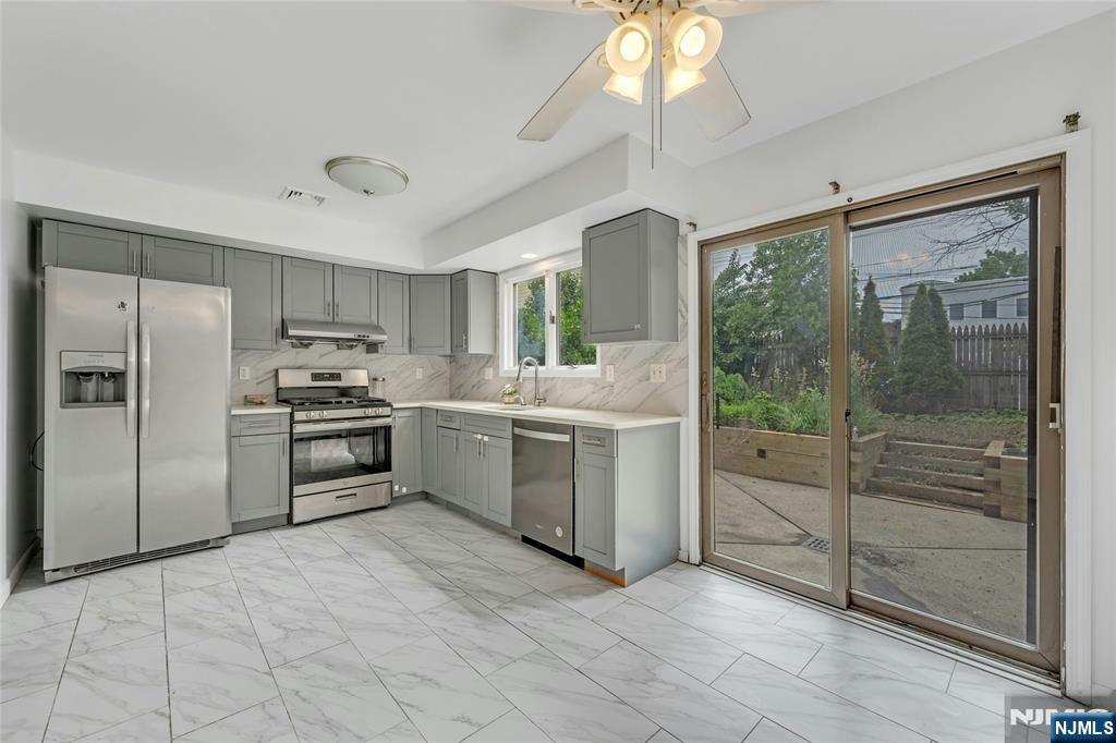 2410 3rd Street Fort Lee, NJ 07024 - Photo 12 of 37 a kitchen with white cabinets and stainless steel appliances