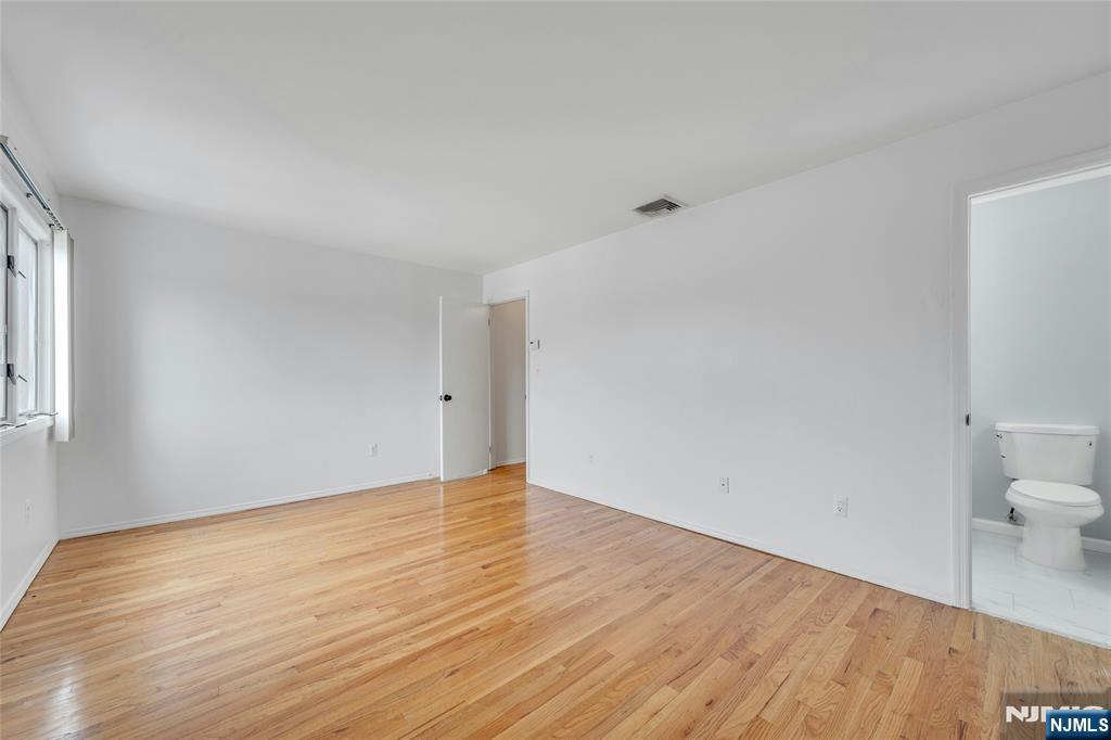 2410 3rd Street Fort Lee, NJ 07024 - Photo 15 of 37 a view of an empty room with wooden floor and a window