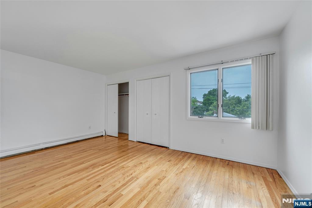 2410 3rd Street Fort Lee, NJ 07024 - Photo 16 of 37 a view of an empty room with wooden floor and a window