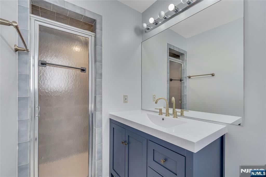 2410 3rd Street Fort Lee, NJ 07024 - Photo 17 of 37 a bathroom with a sink vanity and a mirror