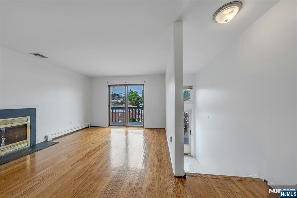 2410 3rd Street Fort Lee, NJ 07024 - Photo 2 of 37 a view of an empty room with wooden floor and a window