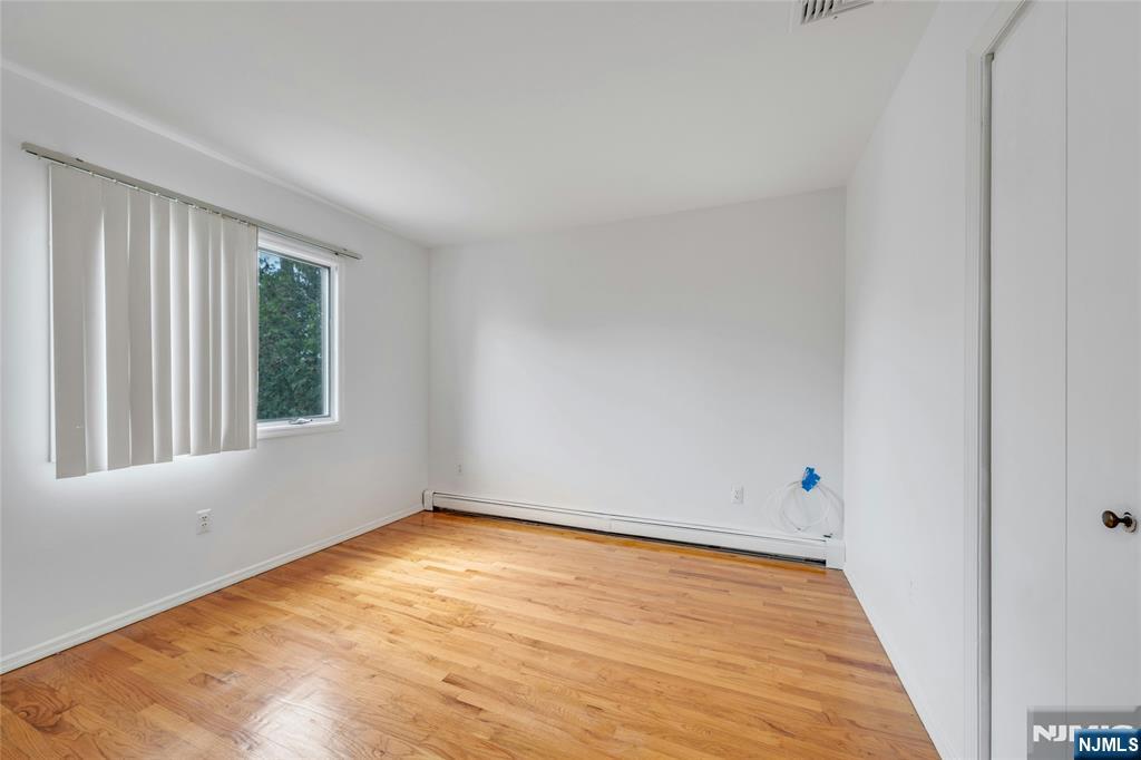 2410 3rd Street Fort Lee, NJ 07024 - Photo 21 of 37 a view of an empty room with wooden floor and a window