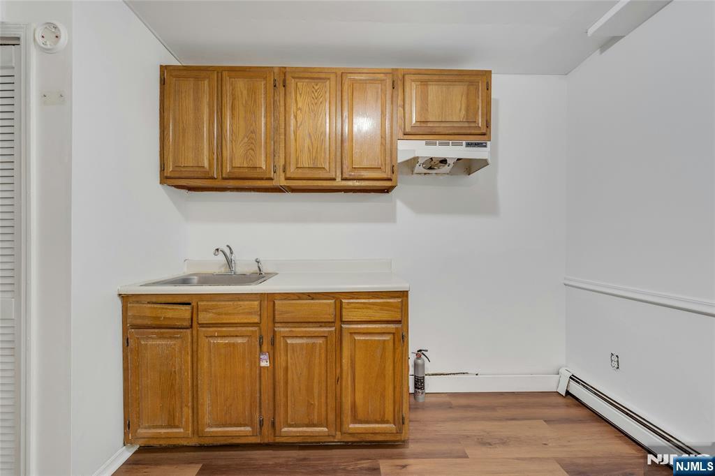 2410 3rd Street Fort Lee, NJ 07024 - Photo 23 of 37 a view of a kitchen with wooden floor and cabinets