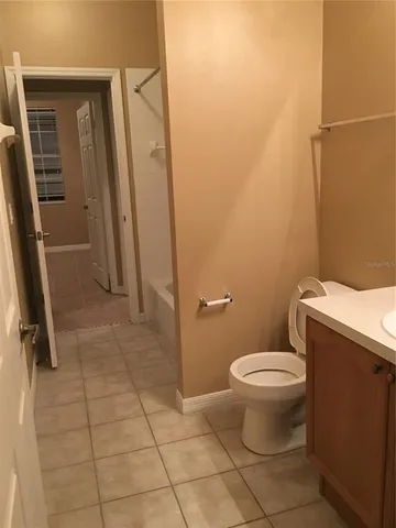 a bathroom with a granite countertop toilet and a sink
