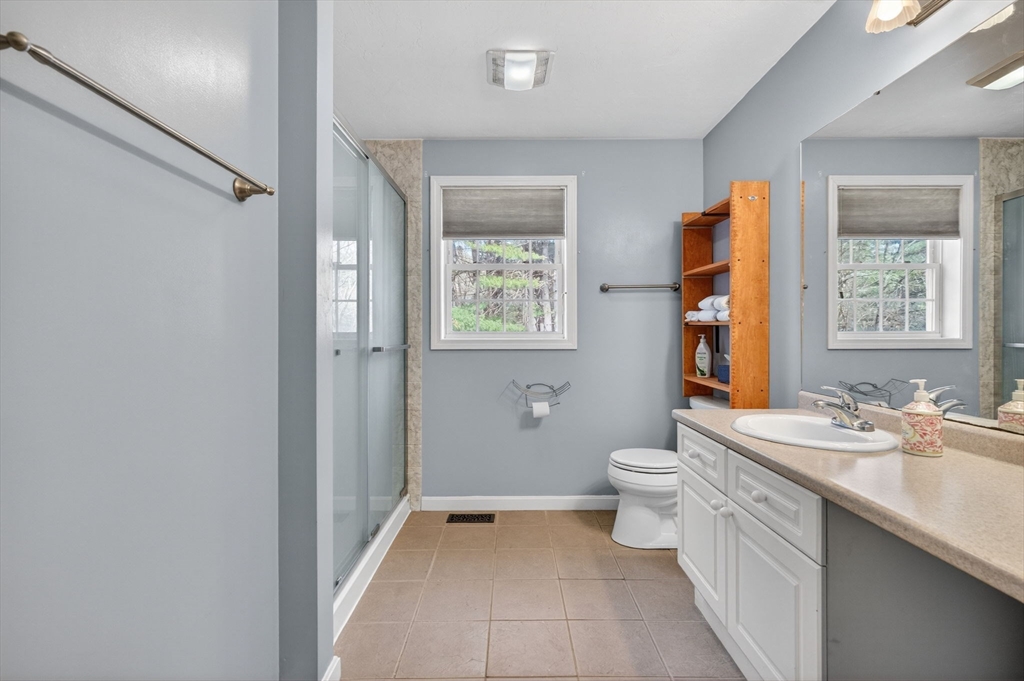 155 Brook Street Hudson, MA 01749 - Photo 28 of 42 a bathroom with a double vanity sink a toilet and a mirror
