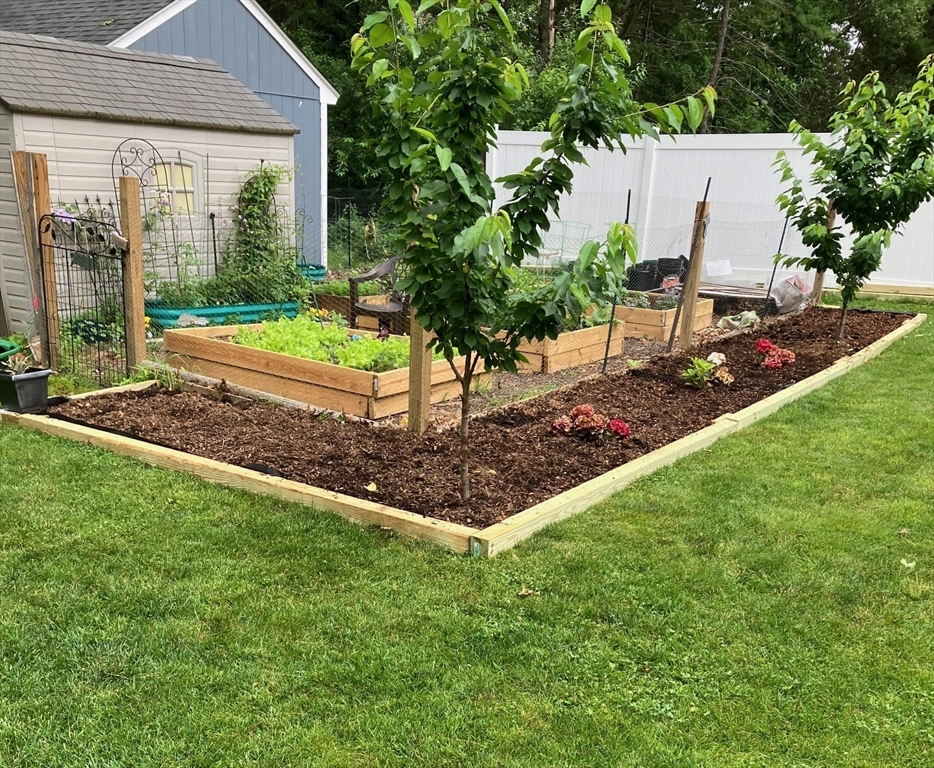 155 Brook Street Hudson, MA 01749 - Photo 36 of 42 a view of a backyard with table and chairs and potted plants