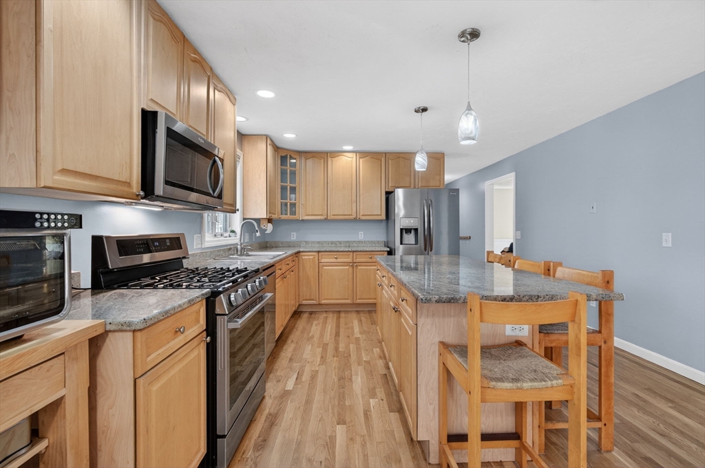 155 Brook Street Hudson, MA 01749 - Photo 4 of 42 a large kitchen with stainless steel appliances granite countertop a stove a sink and a microwave