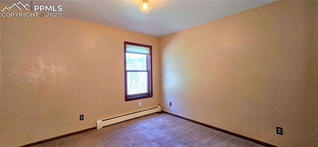 18170 Forest View Road Monument, CO 80132 - Photo 13 of 32 Unfurnished room featuring a baseboard radiator, carpet, and baseboards