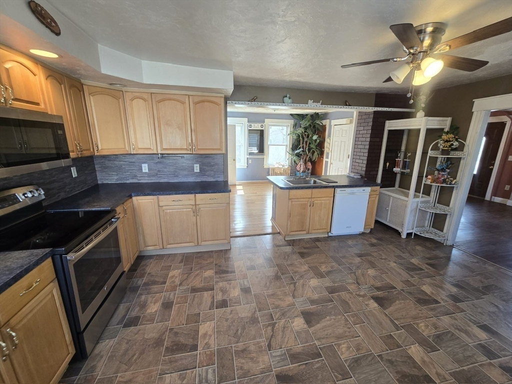 14 Chestnut Avenue, Unit 2 Auburn, MA 01501 - Photo 13 of 41 a kitchen with stainless steel appliances granite countertop a refrigerator a stove top oven a sink a dining table and chairs