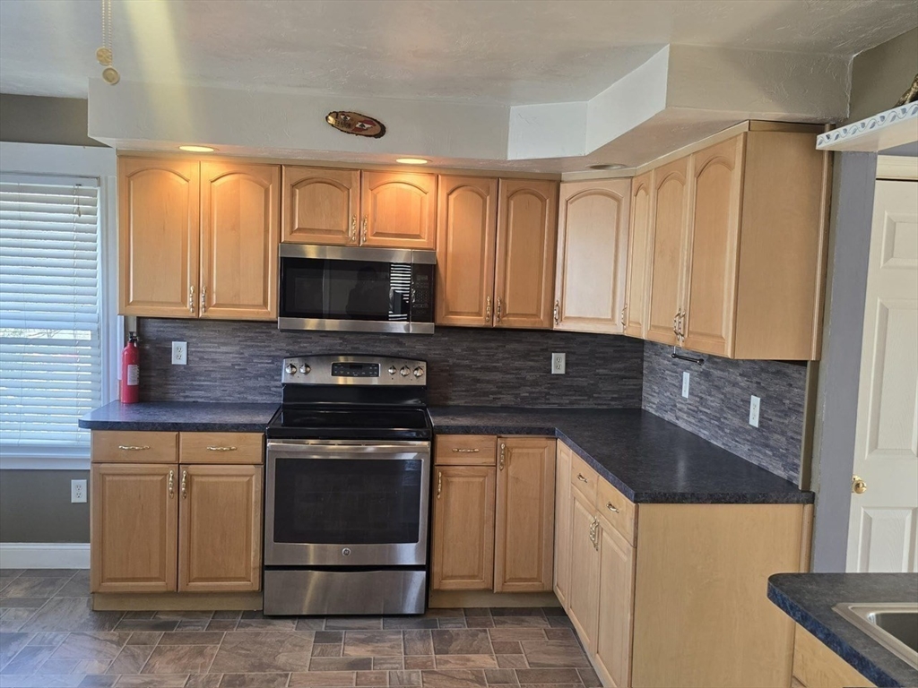 14 Chestnut Avenue, Unit 2 Auburn, MA 01501 - Photo 16 of 41 a kitchen with granite countertop a stove and a sink