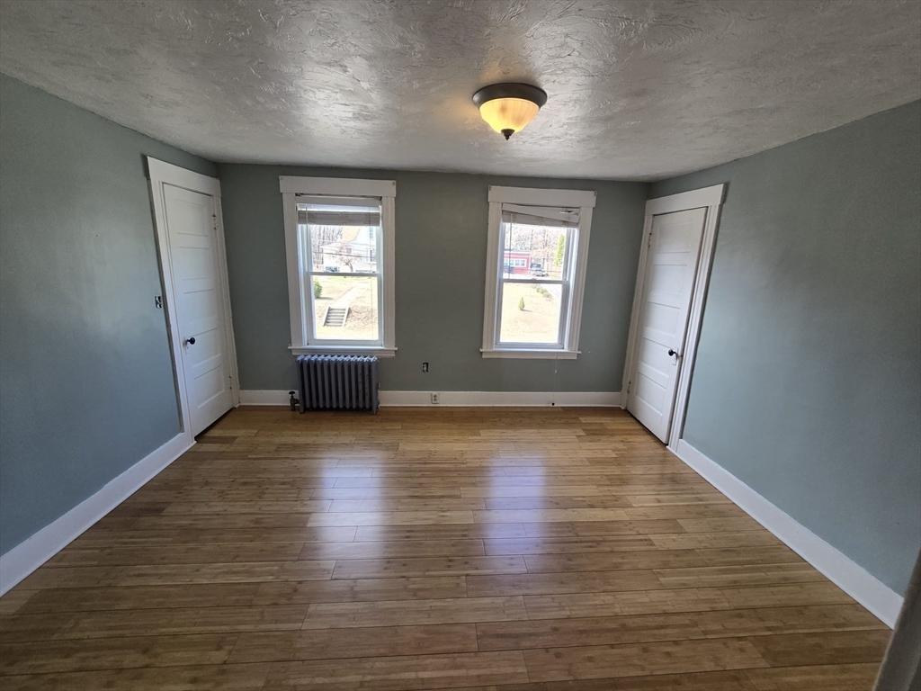14 Chestnut Avenue, Unit 2 Auburn, MA 01501 - Photo 31 of 41 an empty room with wooden floor and windows
