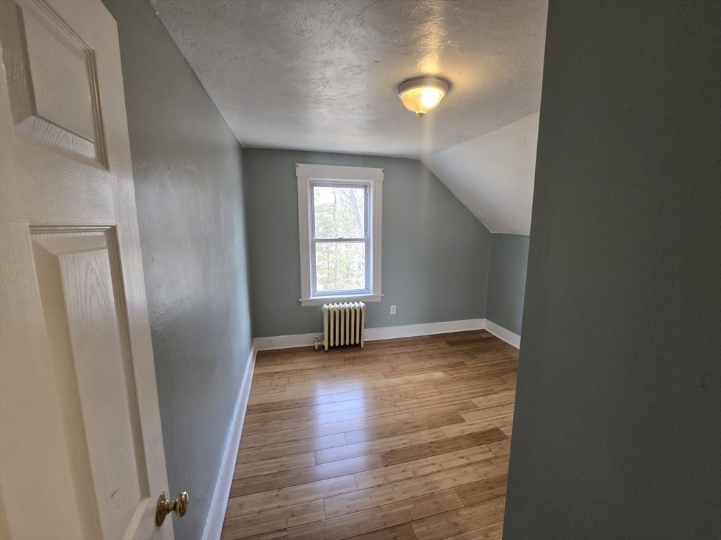 14 Chestnut Avenue, Unit 2 Auburn, MA 01501 - Photo 35 of 41 an empty room with wooden floor and windows