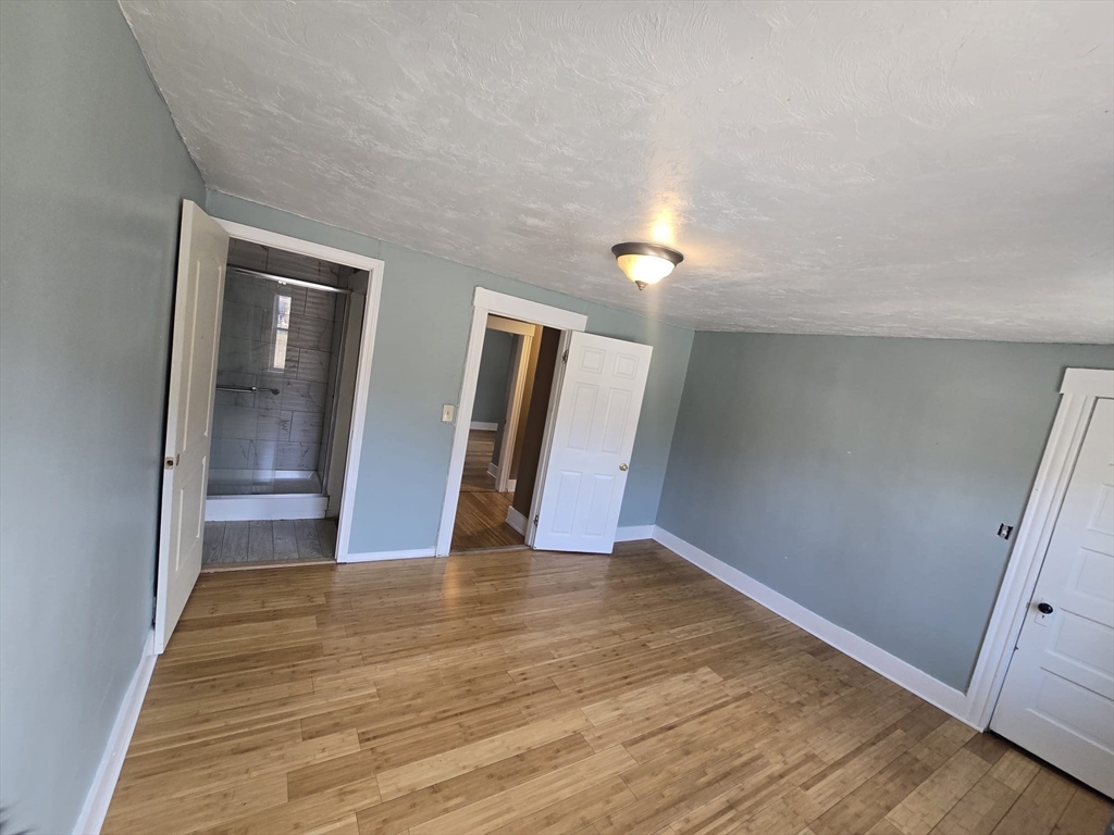 14 Chestnut Avenue, Unit 2 Auburn, MA 01501 - Photo 38 of 41 a view of an empty room with wooden floor and a window