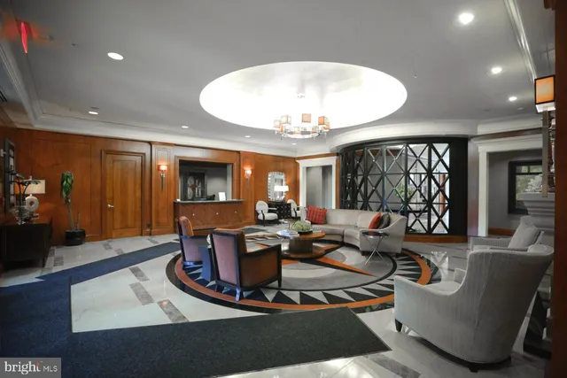 a living room with furniture a large window and a chandelier