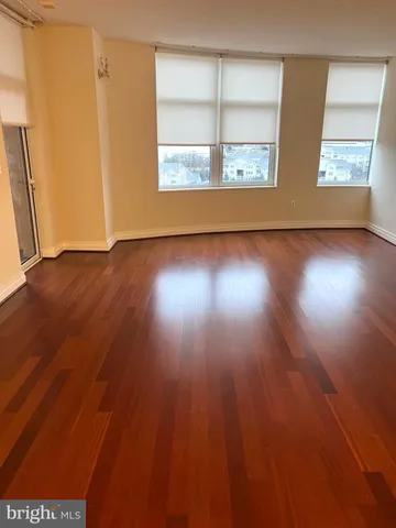 a view of a kitchen with a fridge and wooden floor