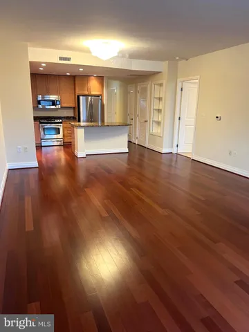 a kitchen with stainless steel appliances granite countertop a refrigerator a stove and a wooden floors