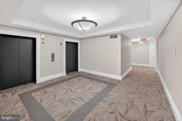 a view of a hallway with furniture and a potted plant