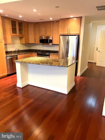 a living room with stainless steel appliances wooden floors and view living room