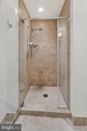 a kitchen with stainless steel appliances granite countertop a refrigerator a sink a stove and white cabinets with wooden floor