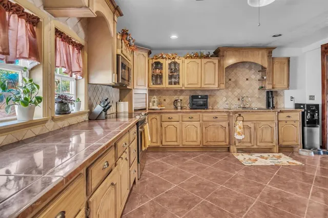 a large kitchen with stainless steel appliances granite countertop a sink and cabinets