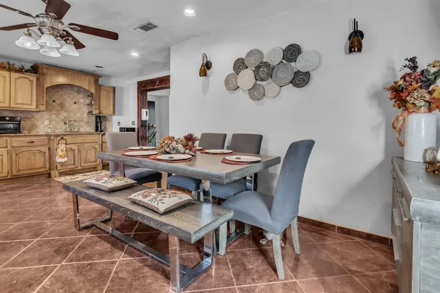a dining room with wooden floor a chandelier a wooden table and chairs