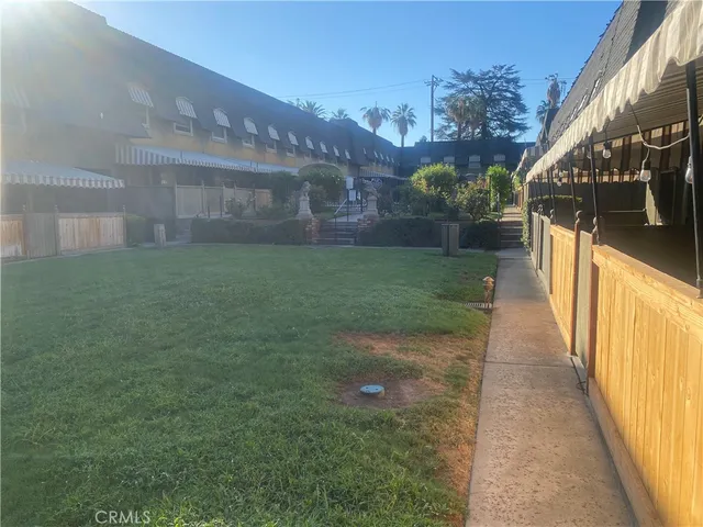 a front view of a house with a yard and potted plants