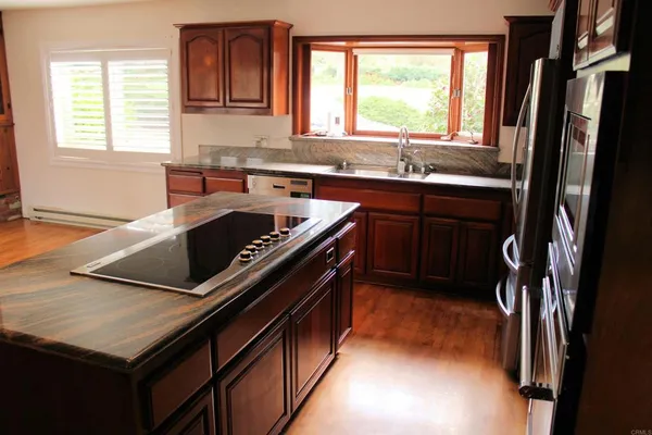 a kitchen with sink a window and cabinets