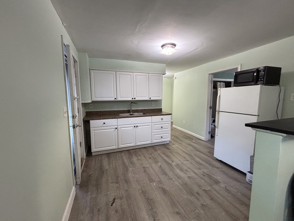 47 Grove Street Spencer, MA 01562 - Photo 18 of 27 a kitchen with granite countertop a refrigerator a sink and white cabinets