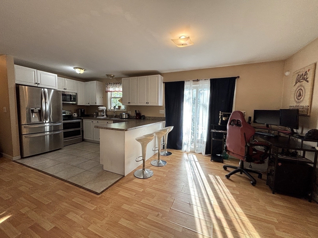 47 Grove Street Spencer, MA 01562 - Photo 4 of 27 a kitchen with stainless steel appliances a refrigerator a stove a sink dishwasher and a refrigerator with wooden floor