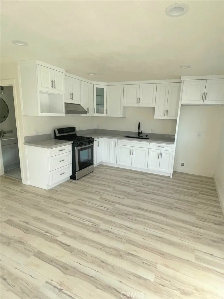 a large kitchen with stainless steel appliances granite countertop a stove and a sink