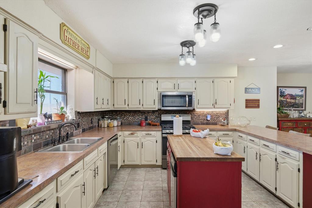 1700 Fm 1995 Van, TX 75790 - Photo 33 of 40 a kitchen with kitchen island granite countertop a sink stainless steel appliances and white cabinets