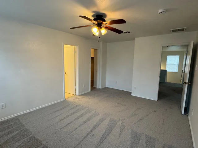 a view of an empty room with a ceiling fan