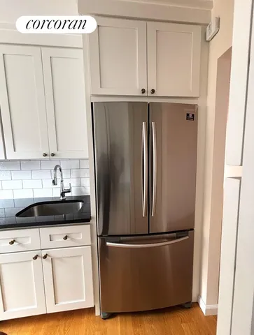 a kitchen with granite countertop a sink a stove and cabinets