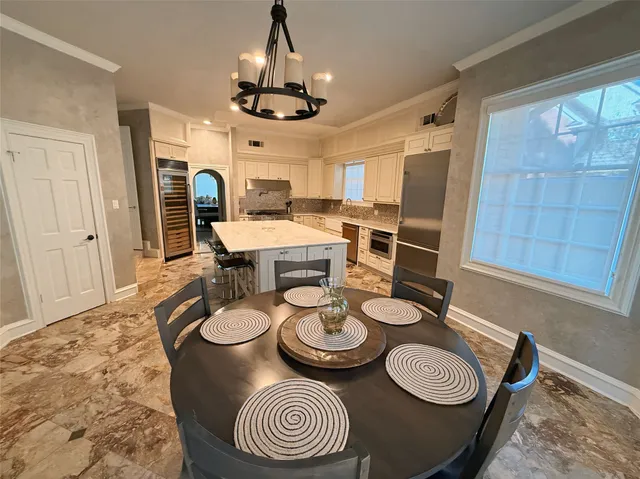 a dining room with furniture a chandelier and wooden floor