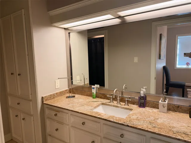 a bathroom with a granite countertop sink and a mirror