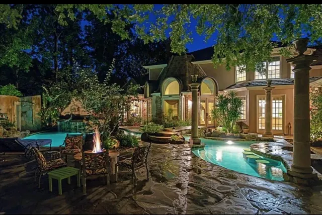 a front view of a house with garden and sitting area