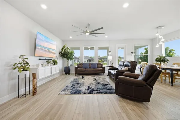 a kitchen with kitchen island stainless steel appliances a sink a stove a refrigerator cabinets and dining table