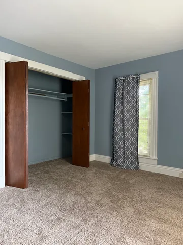 an empty room with closet and a window