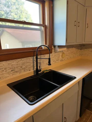 a close up of a sink a counter top and a microwave