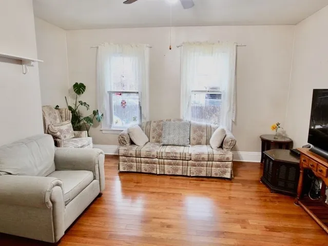 a living room with furniture and wooden floor